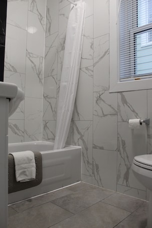 Bañera con ducha, secador de pelo, toallas. Sunrise Inn