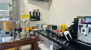 A kitchen area with a coffee machine, condiment dispensers, and a toaster. - Sunrise Inn (Parry Sound)
