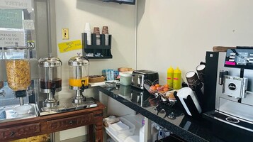 Una cocina equipada con cafetera, dispensadores de condimentos y tostadora.