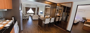 A modern hotel room with a kitchen area, a dining space, and a bedroom. - C'haya Hotel (Kota Kinabalu)