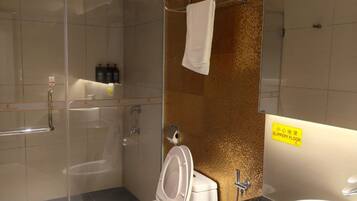 Un bagno moderno con cabina doccia in vetro, un water e un lavandino.