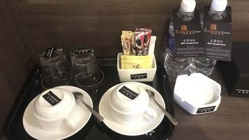 A tray with white bowls, a spoon, a box of tea bags, and two bottles of water labeled "The Imperial Hotel".