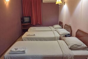 A hotel room with three single beds, a TV on a stand, and a red curtain. - Pantai Inn Kota Kinabalu (Kota Kinabalu)