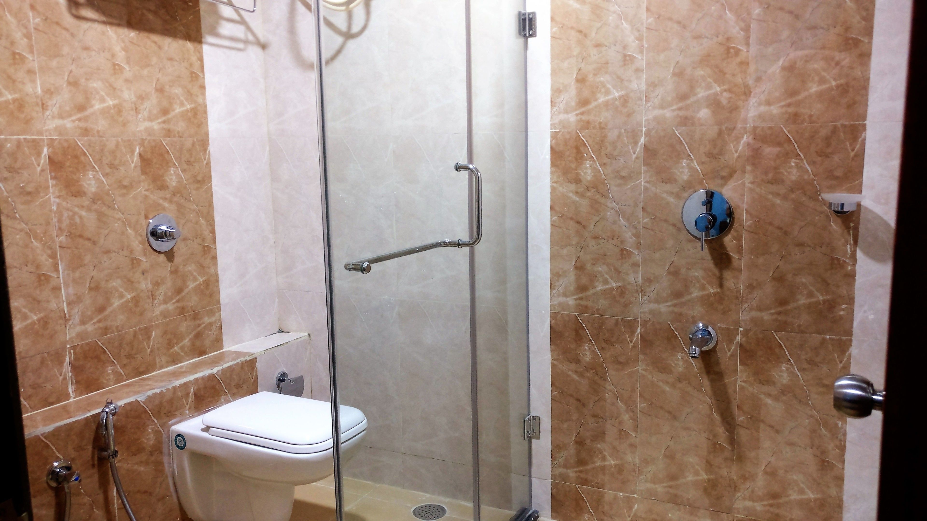 Un baño con ducha de vidrio, inodoro y lavamanos.
