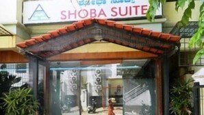 The entrance to a hotel named "SHOBA SUITE" with a tiled floor and potted plants. - Shoba Suites (Bengaluru)