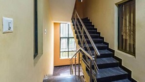 A staircase with metal railings leading to a landing. - Shoba Suites (Bengaluru)