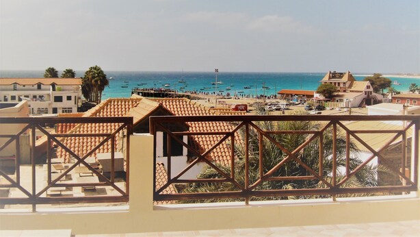 A coastal view with a beach, boats, and buildings. - Patio Antigo Residence (Sal)