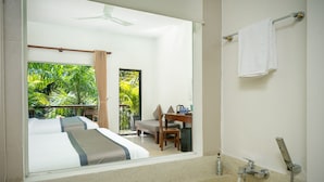 A hotel bathroom with a large mirror, a bathtub, a shower, and a view of a balcony with a bed and a desk. - Landing Gold By Amatak (Siem Reap)