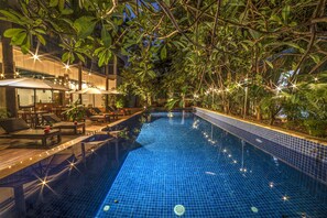 Alberca al aire libre, sombrillas en la alberca y camastros 