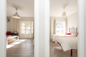 A hotel room with a bed, a desk, and a window.