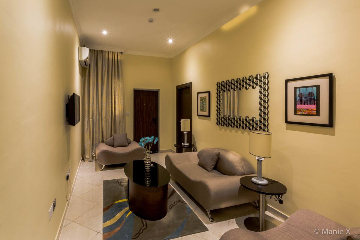 A modern living room with a sofa, a coffee table, and a TV.