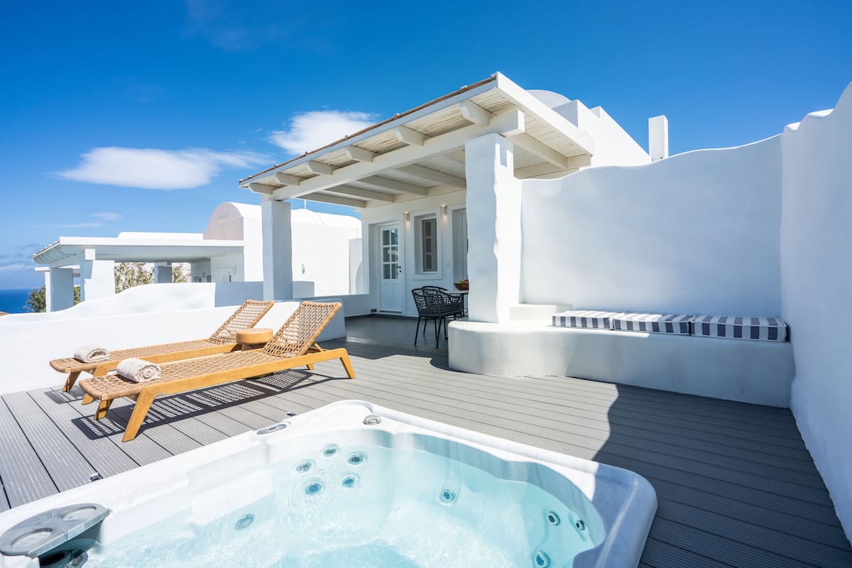 A rooftop terrace with a hot tub, lounge chairs, and a covered seating area.