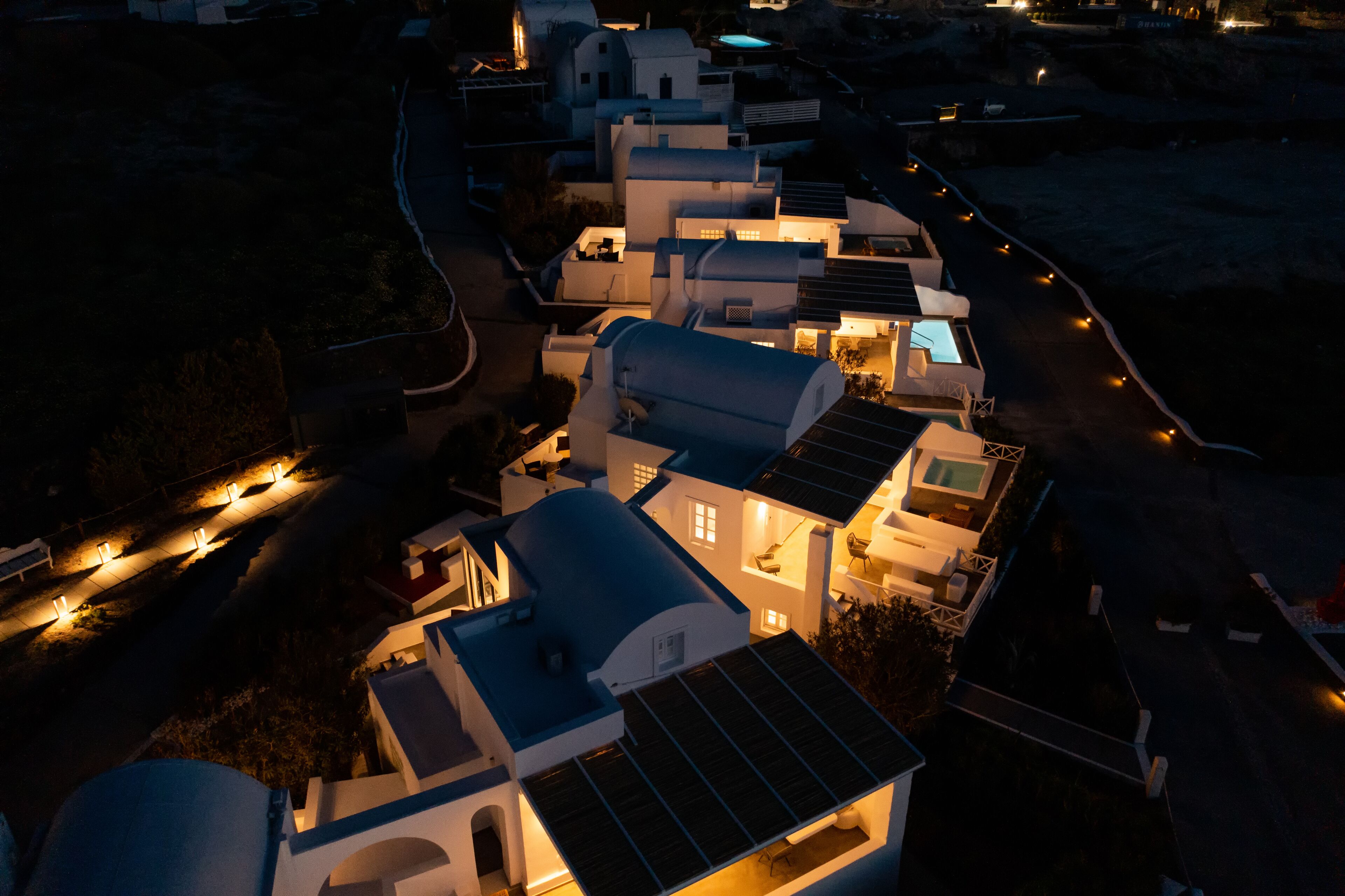 A coastal building complex with multiple structures, including a prominent dome-shaped building with solar panels.
