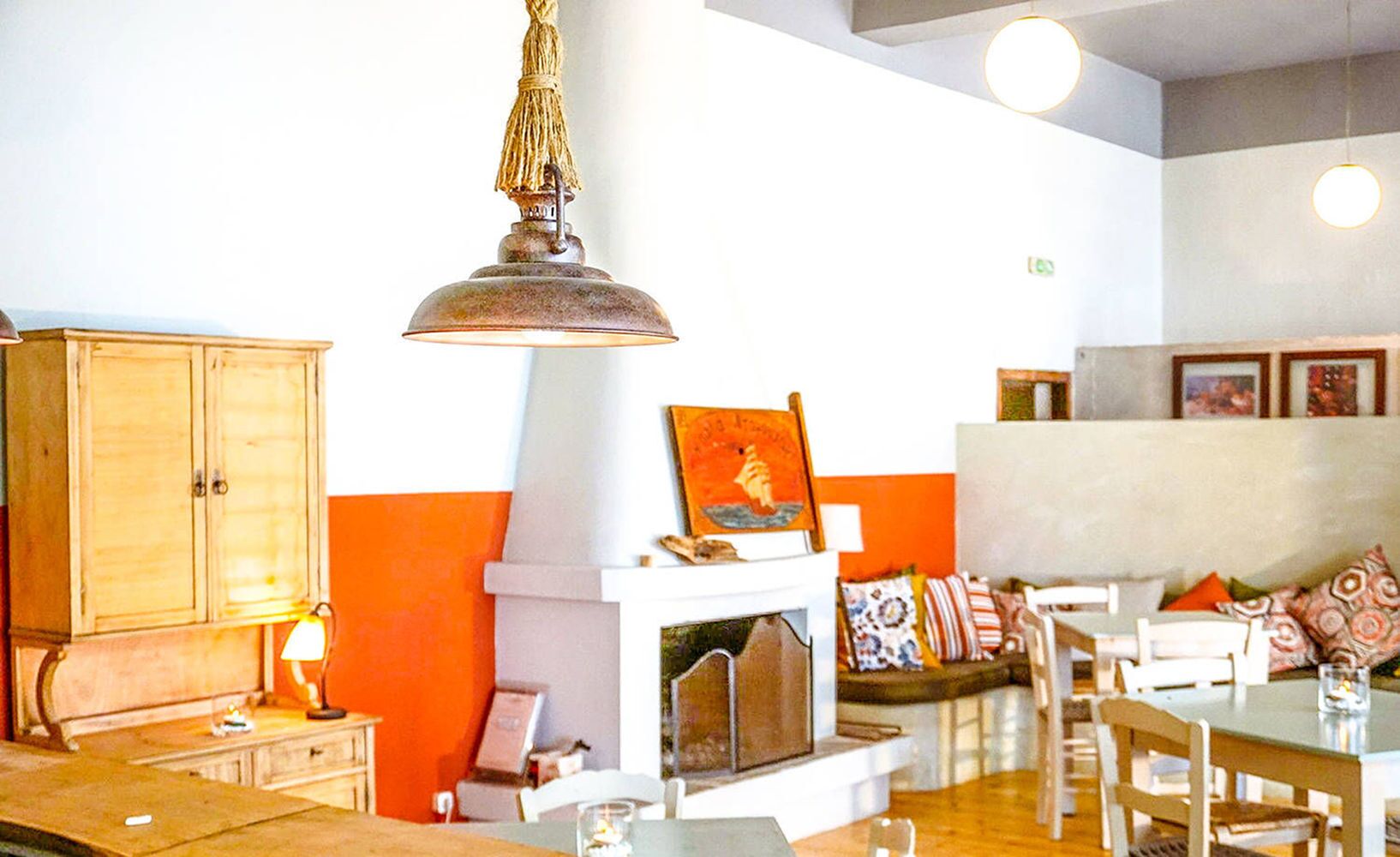 Una sala acogedora con chimenea, muebles de madera y una lámpara colgante.