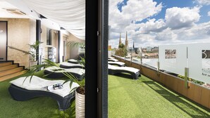 Ein modernes Hotelzimmer mit Blick auf eine Skyline, darunter ein Kirchturm.