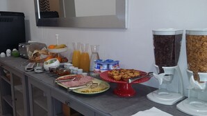 Un bufé de desayuno con diversas opciones de comida, incluyendo frutas, pastelería y bebidas.