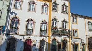 Un edificio de varios pisos con ventanas arqueadas y balcones, que presenta un estilo arquitectónico tradicional.
