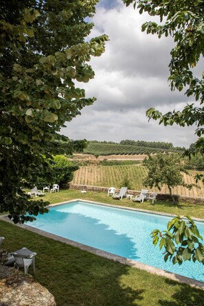Una piscina al aire libre de temporada, sillones reclinables de piscina