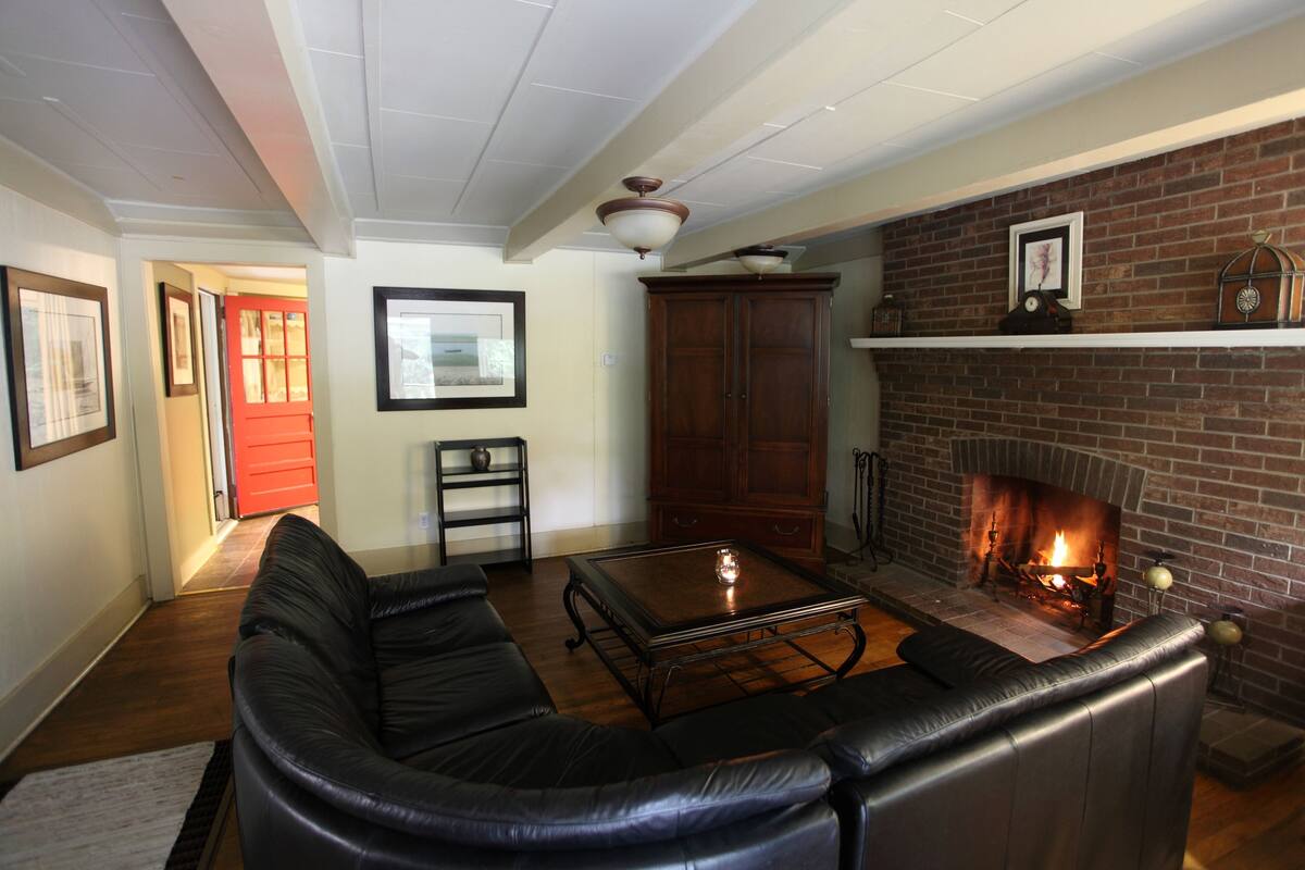A living room with a fireplace, leather sofa, and a coffee table.