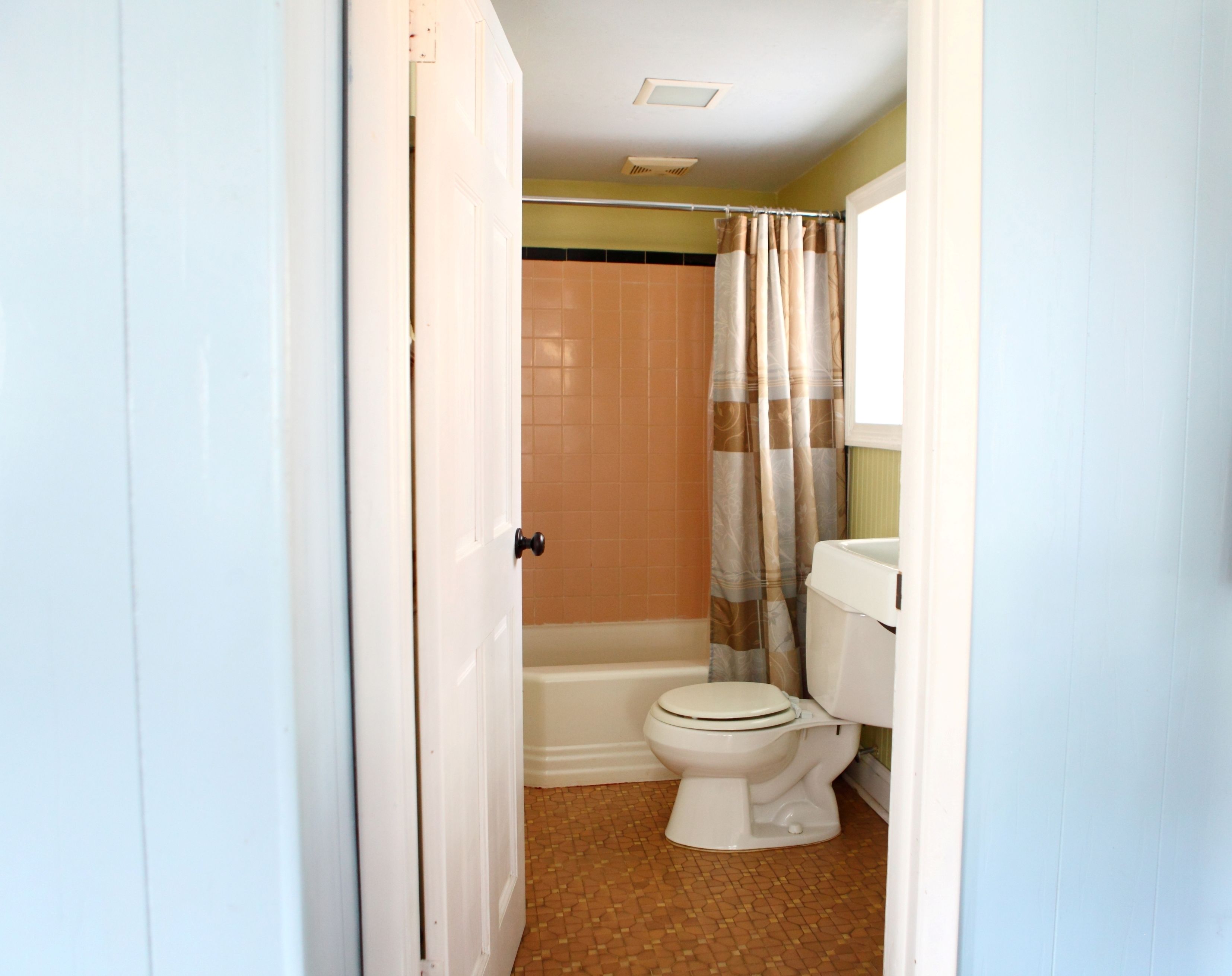 A bathroom with a toilet, bathtub, and shower curtain.