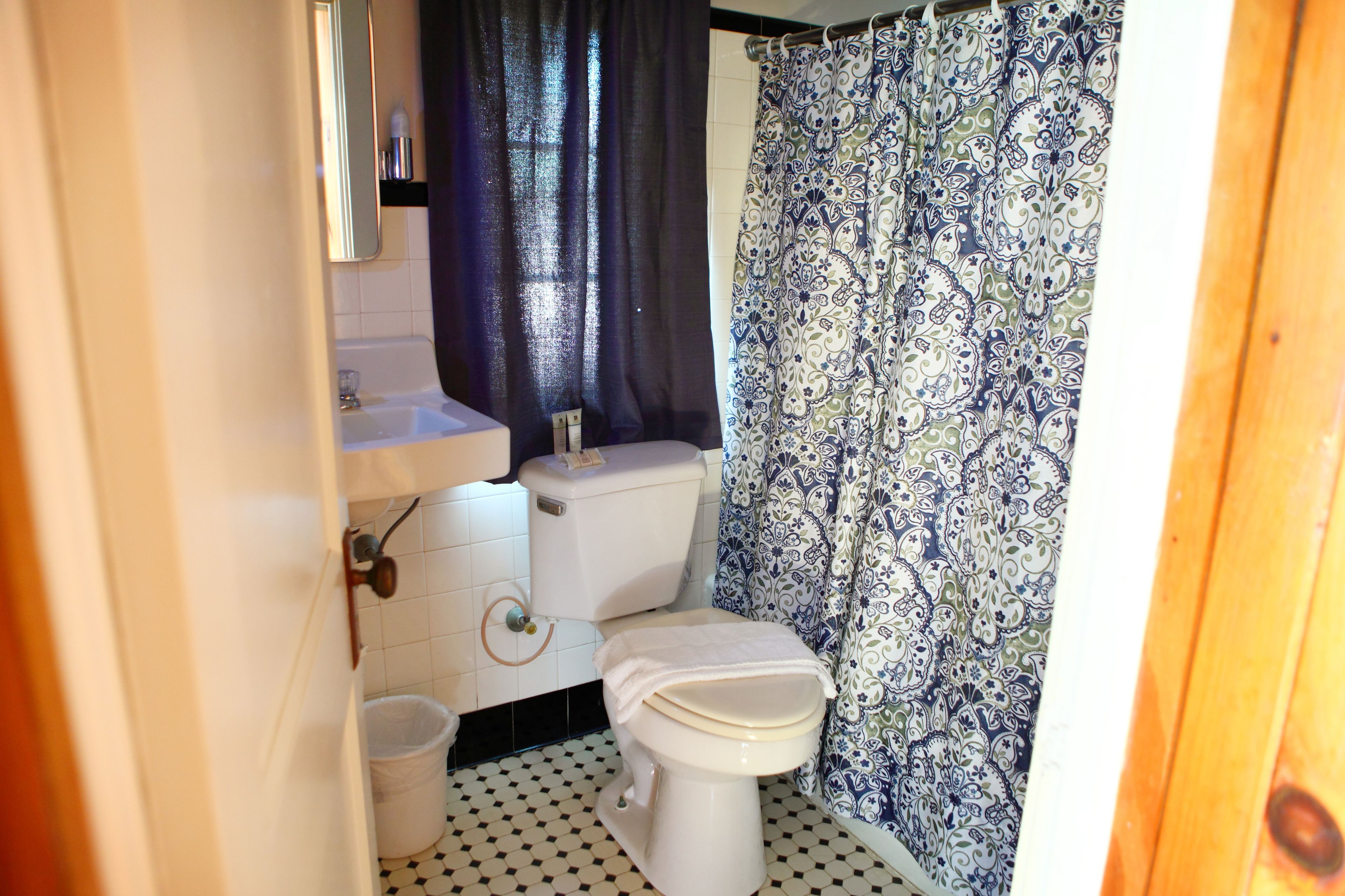 Ein Badezimmer mit Toilette, Waschbecken und Duschvorhang.