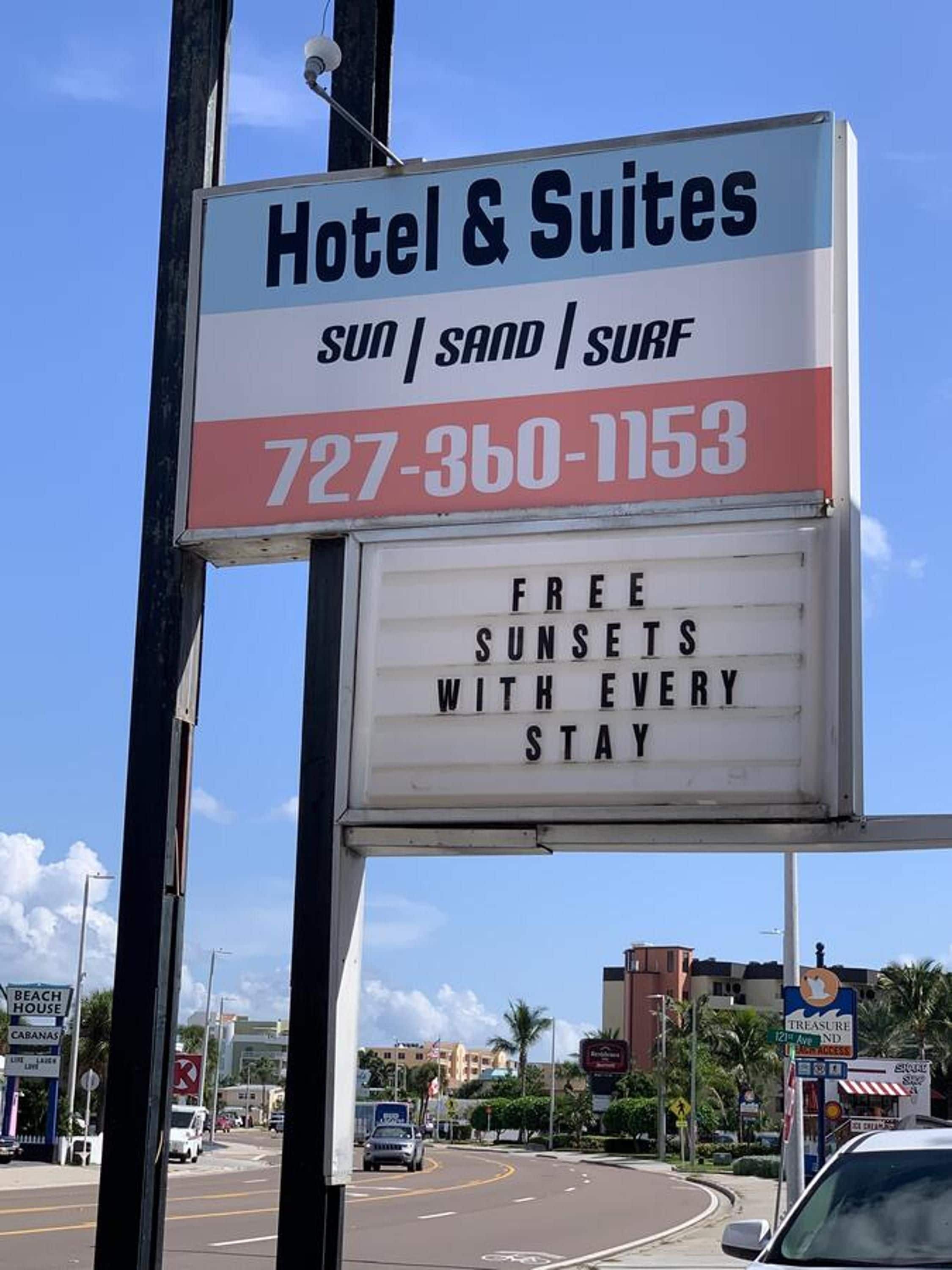 A hotel sign with the name 'Hotel & Suites' and a phone number.
