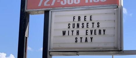 A hotel sign with the name 'Hotel & Suites' and a phone number.