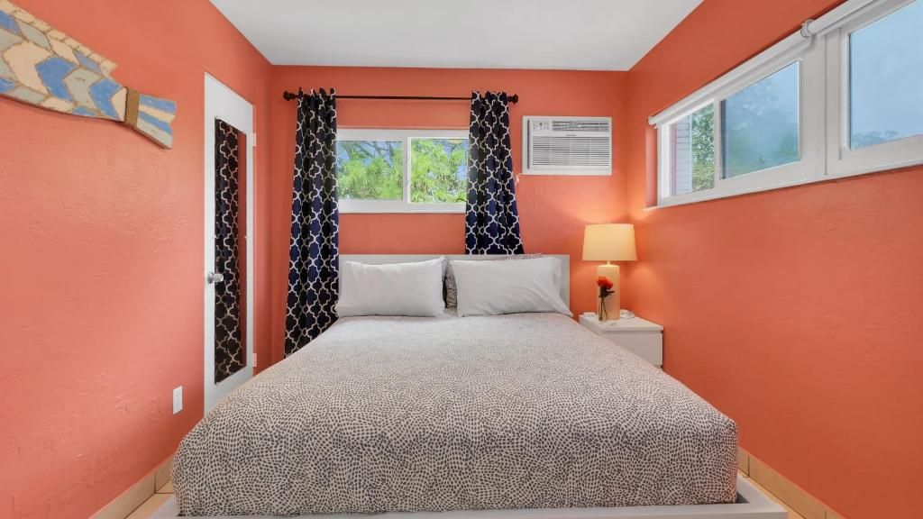 A bedroom with a bed, curtains, a nightstand with a lamp, and a window.