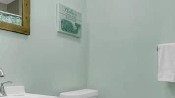 A bathroom with a toilet, sink, and cabinet.