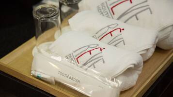 A tray with a toothbrush, a glass of water, and two towels with the word "REIT" on them.
