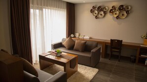 Una sala de estar moderna con un sofá, una mesa de centro y una zona de comedor con una mesa de madera y sillas.