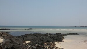 Une plage avec des formations rocheuses et une vue dégagée sur l’océan.