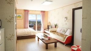 Een knus ingerichte kamer met een bed, een bank, een salontafel en een televisie.