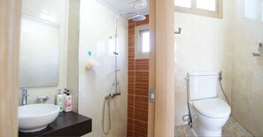 A bathroom with a sink, mirror, shower, and toilet. - Lapaloma Pension (Jeju City)