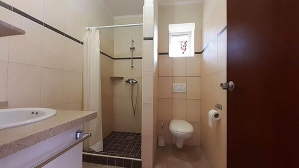 A bathroom with a shower, toilet, and sink. - Wayaca Mini Resort (Jan Thiel)