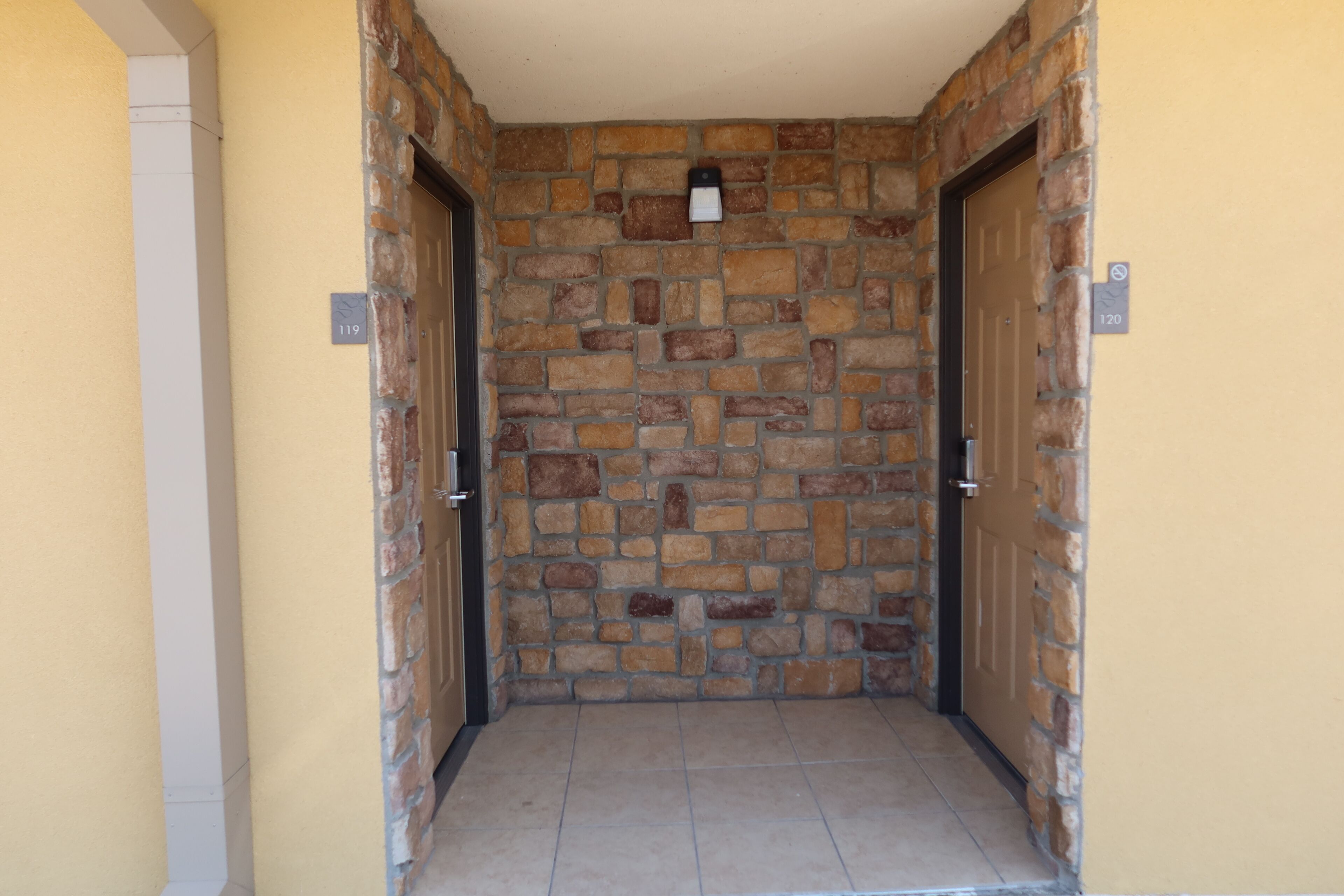 A stone-walled hallway with two doors, each marked with a number.