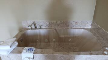 A modern bathroom with a freestanding bathtub, a towel rack, and a toilet paper dispenser.