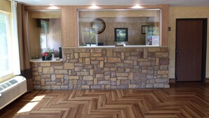 Ein Empfangsbereich mit Steinwand, Holzboden und einer Tür.