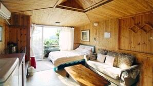 Una habitación acogedora estilo cabaña con una cama, un sofá y un banco de madera.