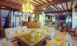 A spacious lobby with a reception desk, sofas, and a chandelier. - Kenia Nevada (Monachil)
