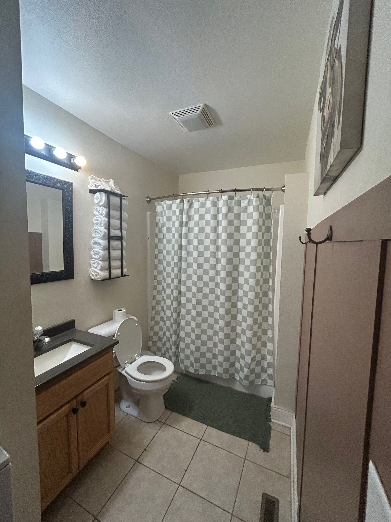 Un baño con lavabo, inodoro y cortina de ducha.