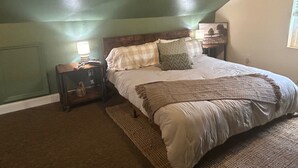 A bedroom with a bed, nightstands, a lamp, and a painting on the wall. - Mountain Cove Farms Resort (Chickamauga)