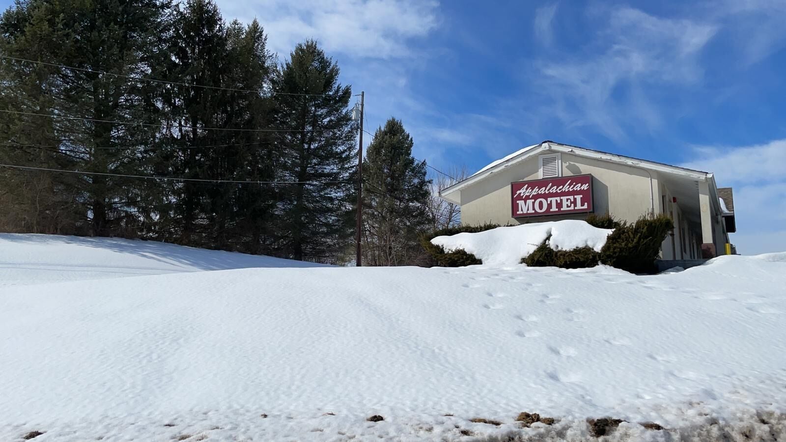 A snow-covered landscape with a motel sign.