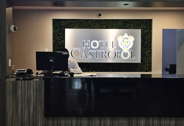 A hotel reception desk with a sign reading "HOTEL CASTROPOL".