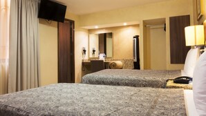 A hotel room with two beds, a television, a mirror, a bathroom, and a telephone. - Hotel Castropol (Mexico City)