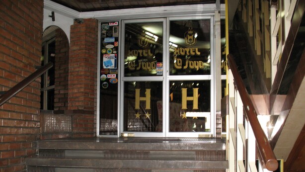 A hotel entrance with a glass door displaying the hotel's name and logo. - Hotel La Joya (La Paz)