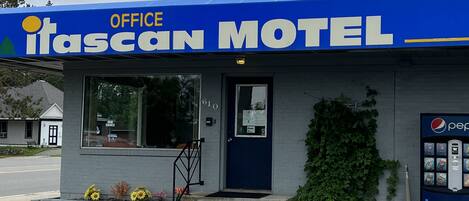 A building with a blue awning labeled "Itasca Motel Office."