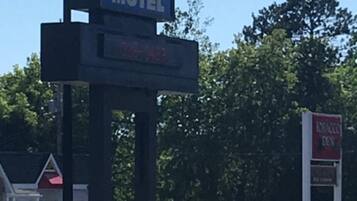 Señal de motel con el nombre 'Itasca Motel' y un panel digital que indica 'Abierto las 24 horas'.