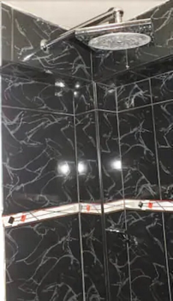 A bathroom with black marble walls and a shower area. - Padama Hotel (Callao)