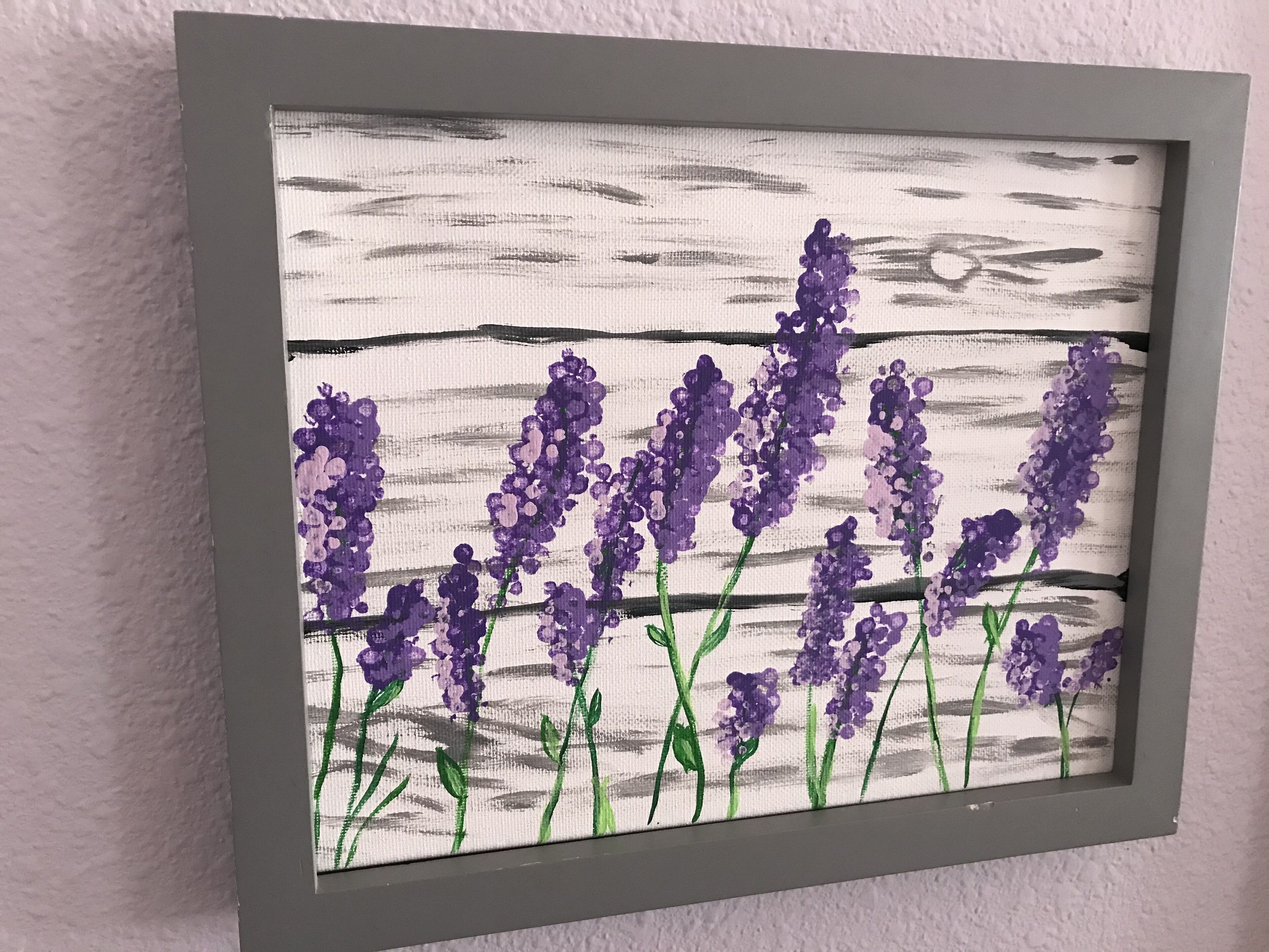 Une œuvre d’art encadrée représentant des fleurs violettes sur un fond texturé.